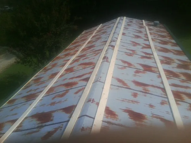 Rusted metal roof panels with new wood purlins before replacement — Storm Damage Roof Repair in Perryville by Roofing Brothers