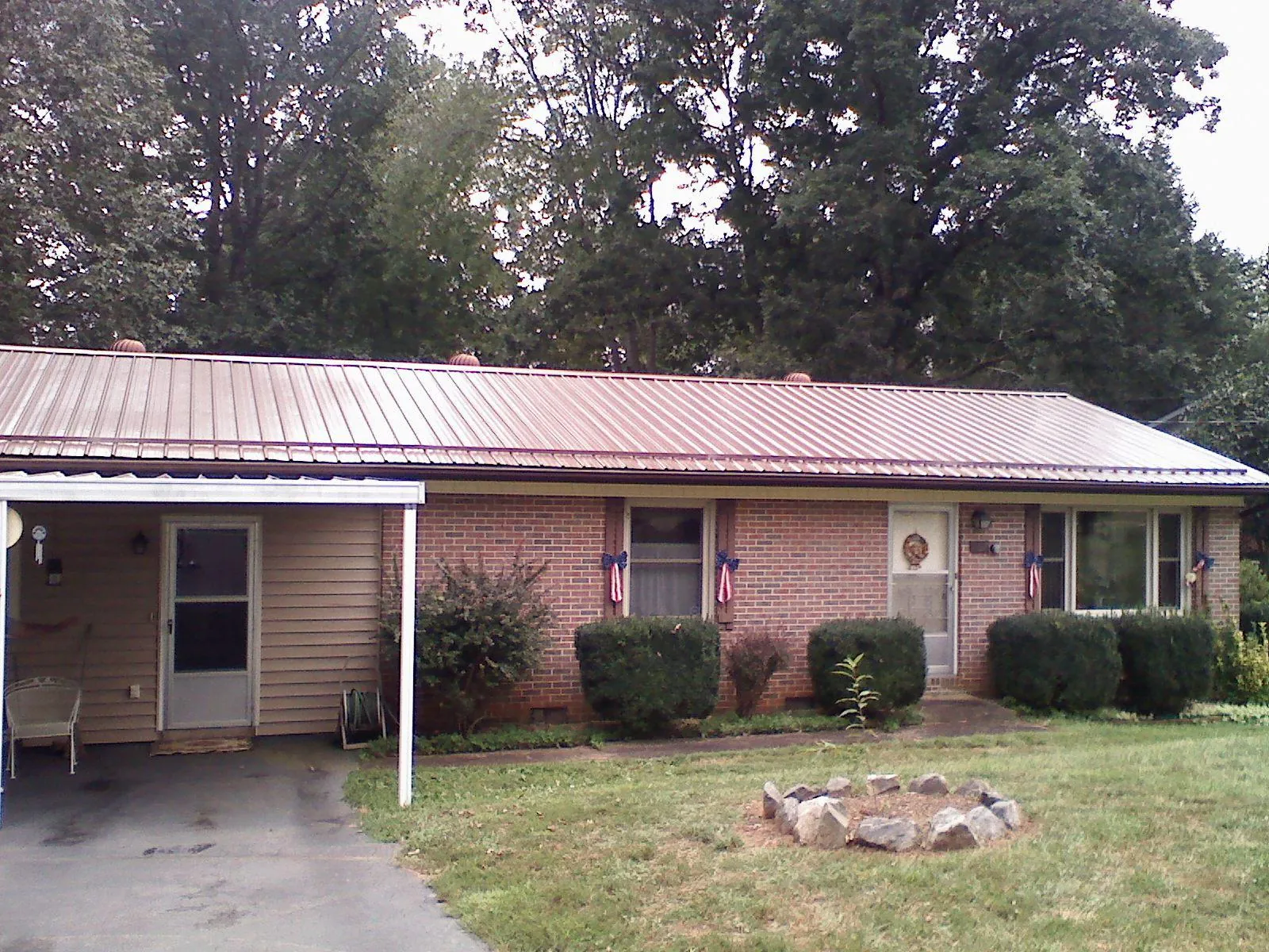 Bronze metal roof and carport on a brick ranch home — Roof Repair work by our crew in Perryville